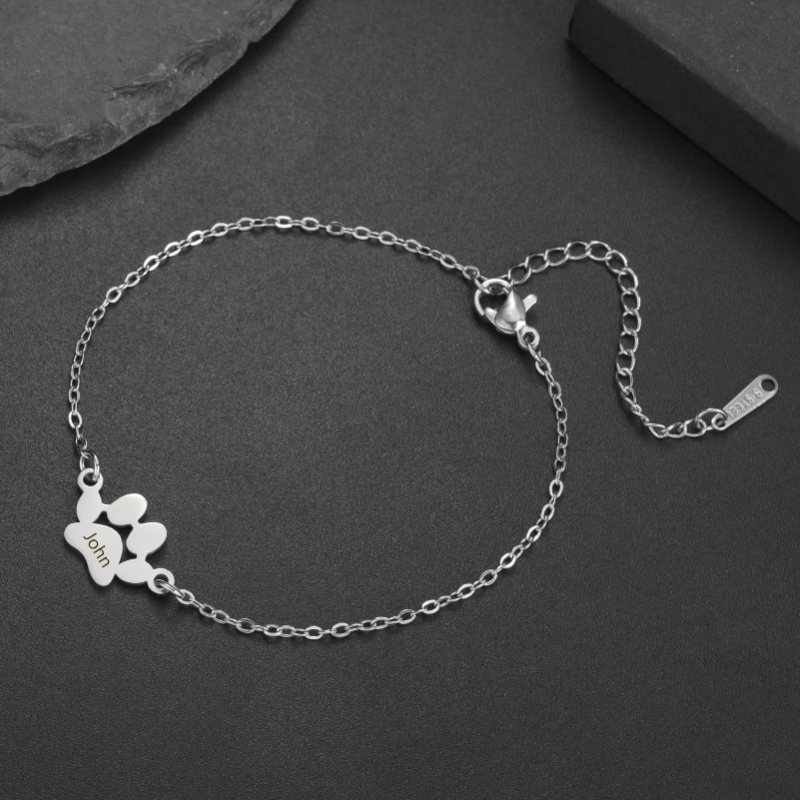 Silver bracelet with a heart charm on a dark surface