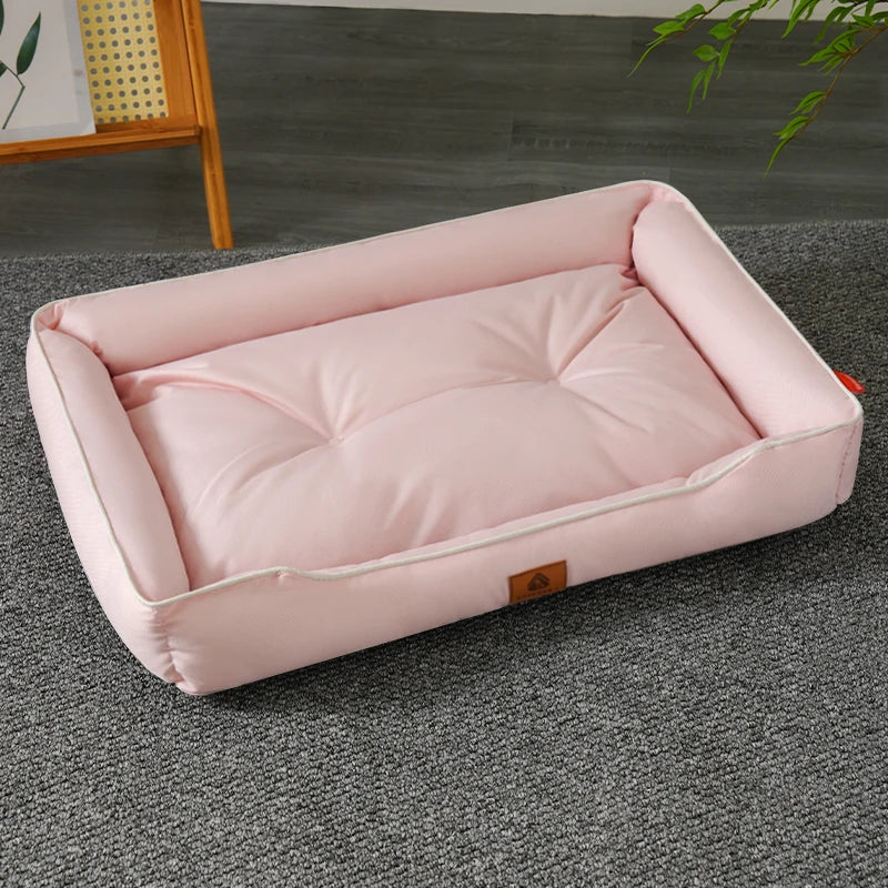 A pink waterproof dog bed made of Oxford fabric, placed on a gray floor.