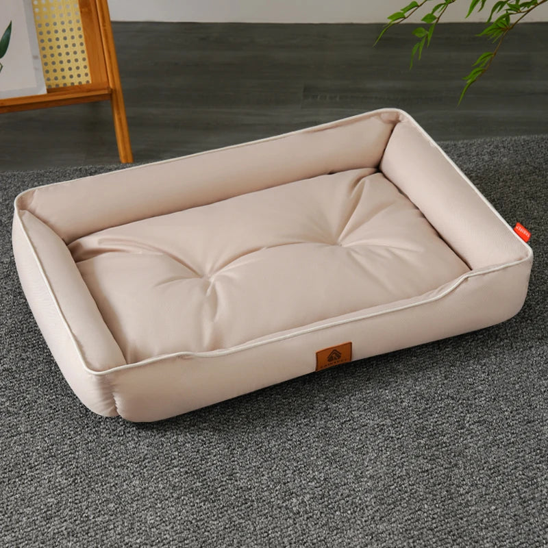 A beige waterproof Oxford dog bed with a plush top, situated on a gray floor.