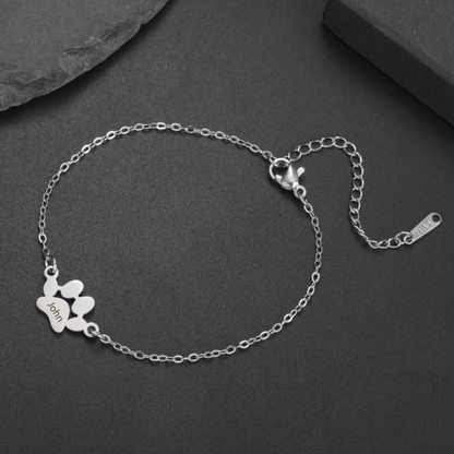 Silver bracelet with a heart charm on a dark surface
