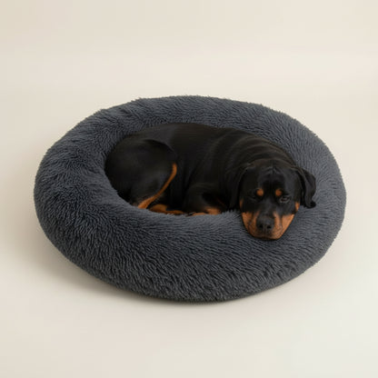 Cama para cão em peluche cinza-escuro em formato de donut.