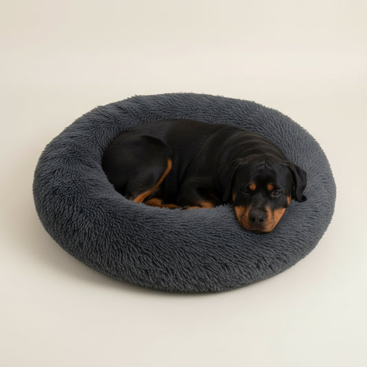 Cama para cão em peluche cinza-escuro em formato de donut.