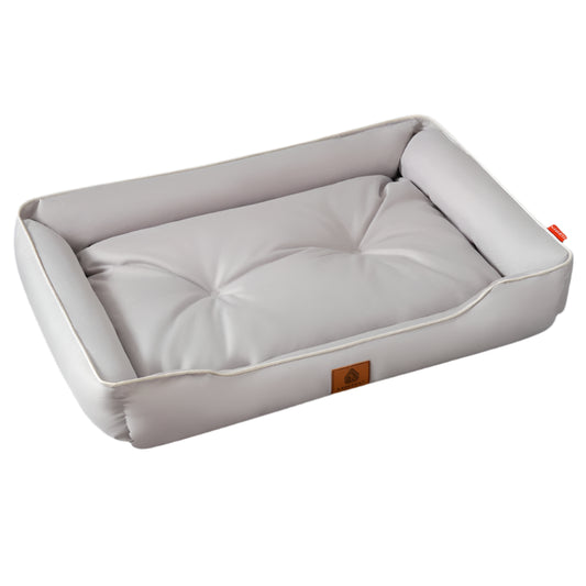 Gray pet bed with a brand logo on a dark gray floor.